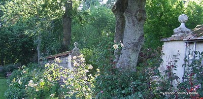 visiting-valley-rose-gardens-miserey-my-french-country-home large tree surrounded by flower bed and garden walls