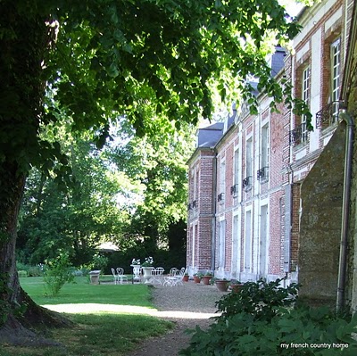 visiting-valley-rose-gardens-miserey-my-french-country-home back of the manor house with small white tables on a terrace