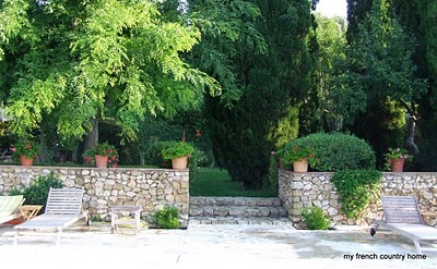 a stone wall and staircase leading into a garden