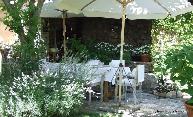summertime-living-easy-2-my-french-country-home outdoor dining space with white linen tablecloth and umbrellas