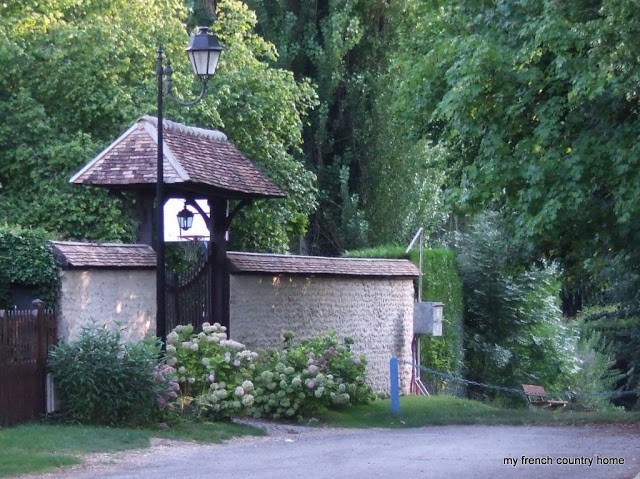 covered gateway with hydrangeas in front