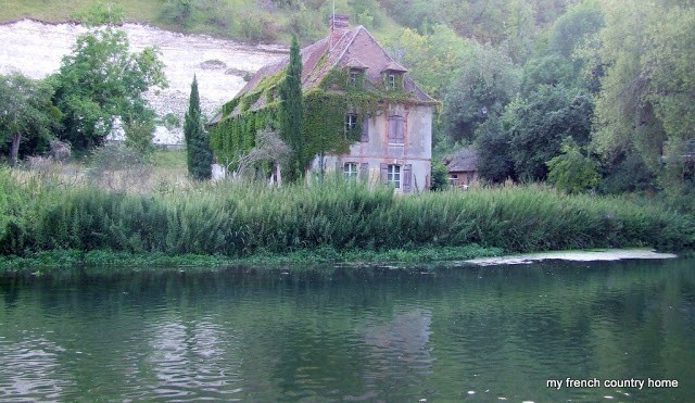 old, ivy-covered home on a river