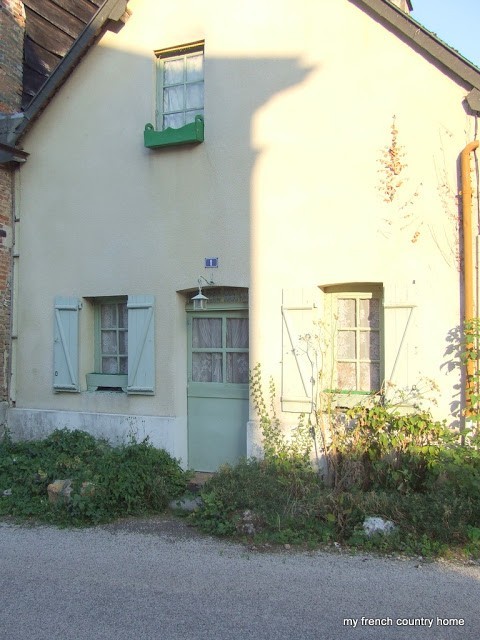 side of a home with green door and shutters