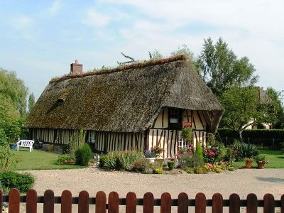 thatch-roofed cottage with exposed beams and garden