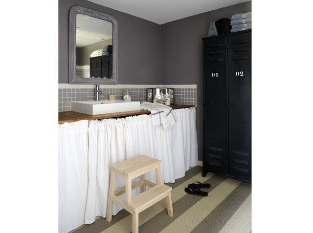 black and white bathroom with curtains under the counter and black lockers