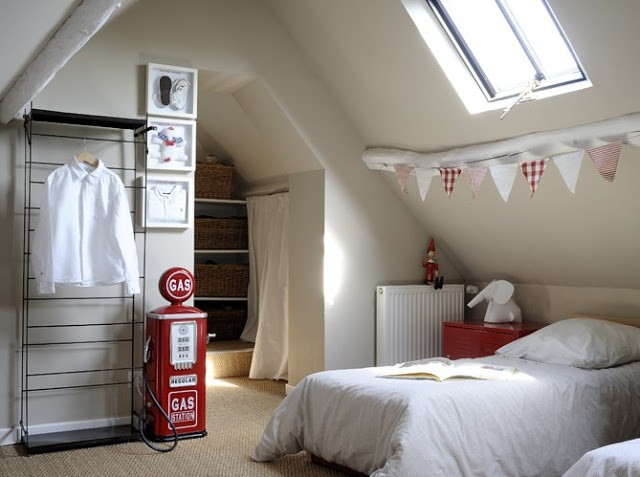 small attic bedroom with wire shelves and red accents