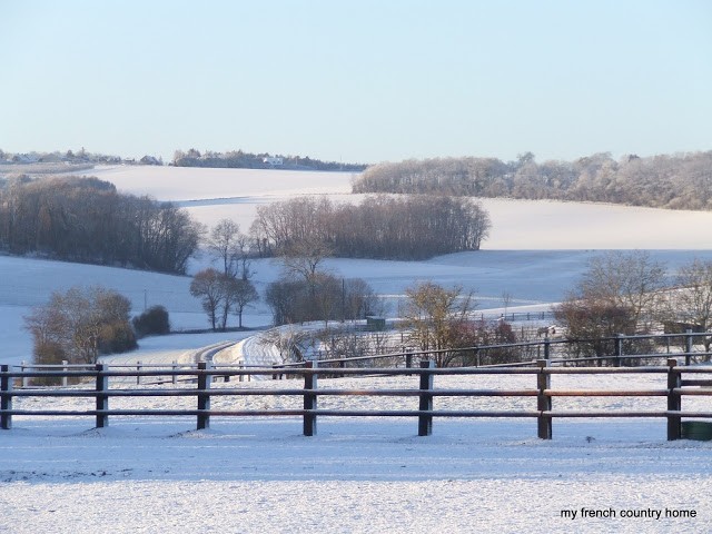 snowy country landscape with fence in foreground