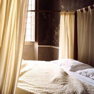 cream linens on a bed with drapes