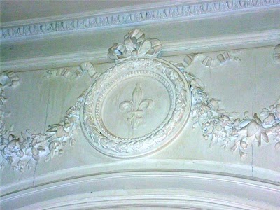 detailing of the ceiling moulding with garlands and fleur-de-lys medallion