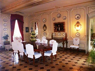 large dining room with table and chairs, and china on the walls