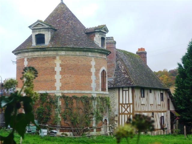 rounded brick tower and an exposed beam house with ivy