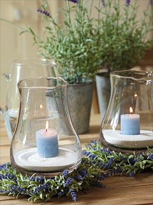 romantic centerpiece with blue candles in glass vases and lavender in tin pots