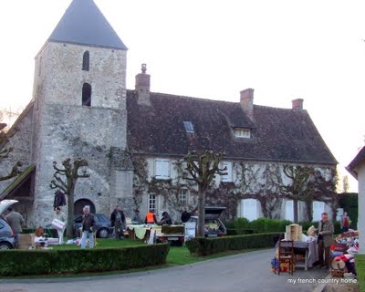 early-sunday-brocante-my-french-country-home small town brocante fair, with tables set up in front of the stone church