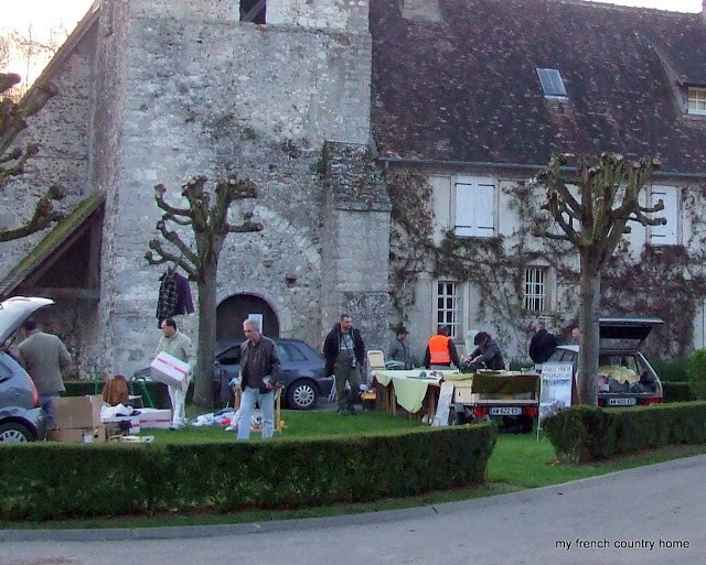 early-sunday-brocante-my-french-country-home tables set up in the courtyard of a stone church