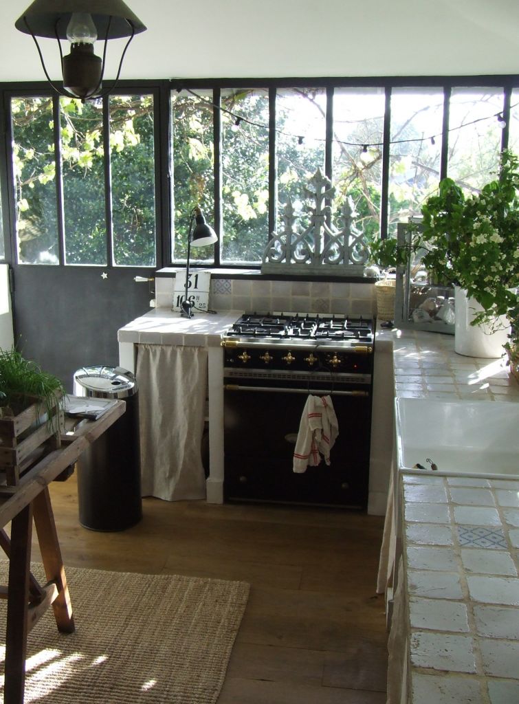kitchen with wall of windows and black stove