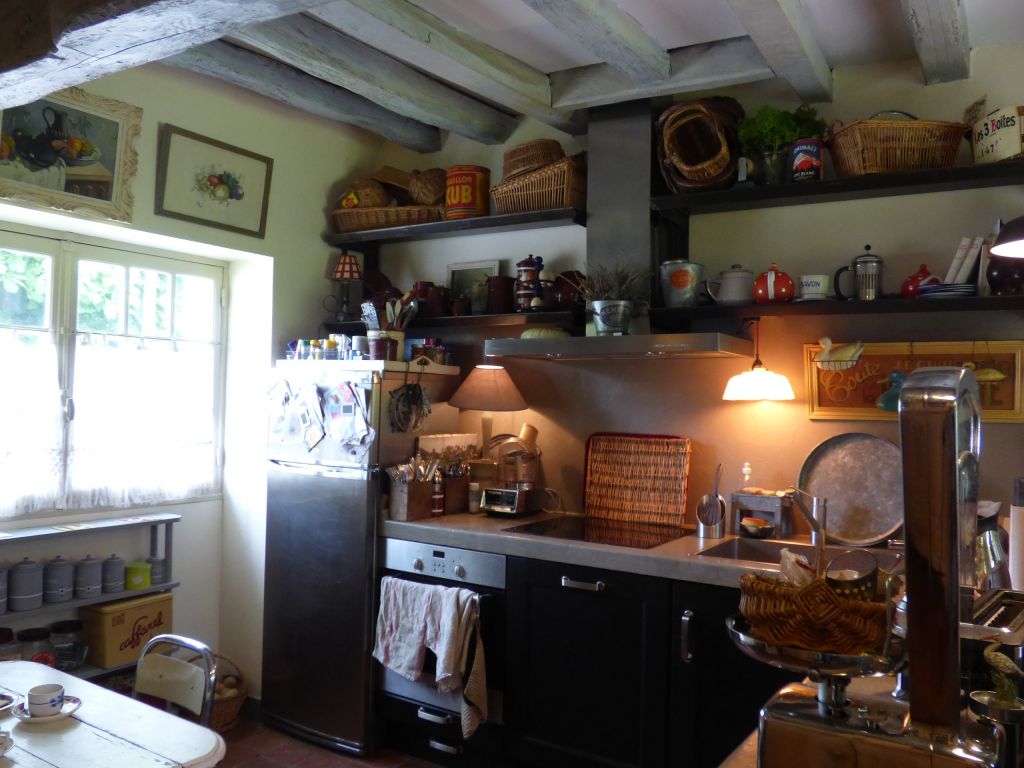 bright kitchen with shelves and white beams