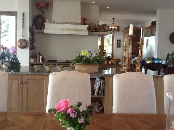 real-french-kitchens-home-pics-my-french-country-home kitchen area with island, seen from across large dining table with white chairs