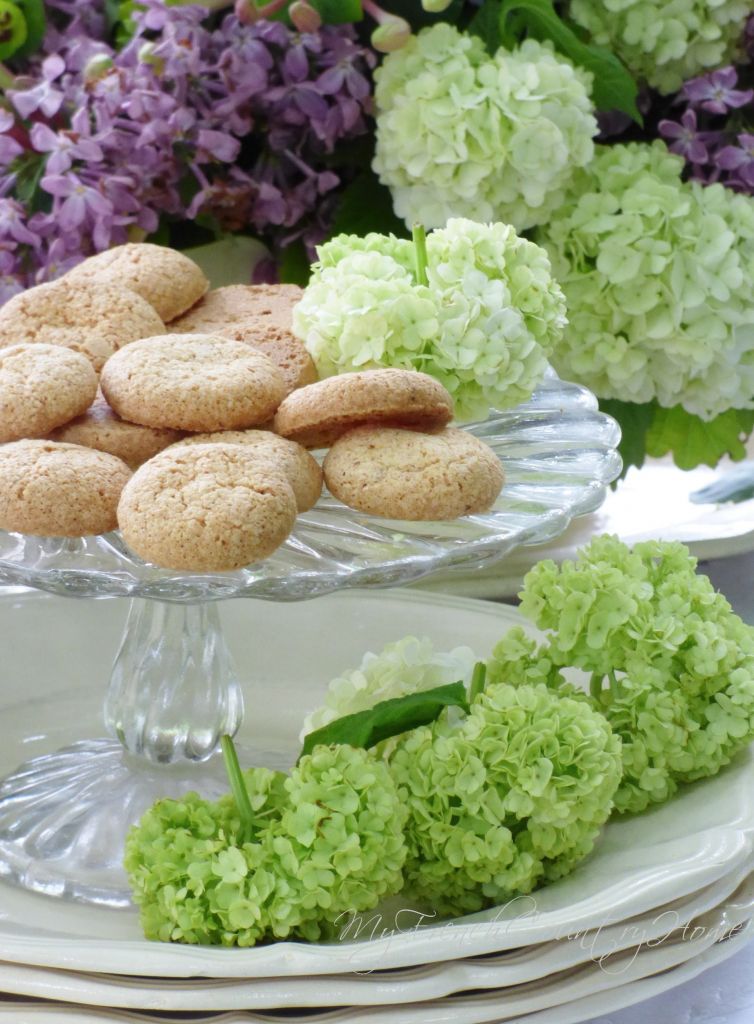 table laid for tea with flowers arrangement and pile of plates