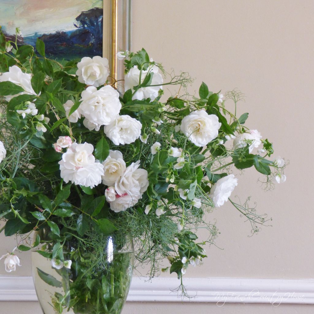 white roses and peas in a vase