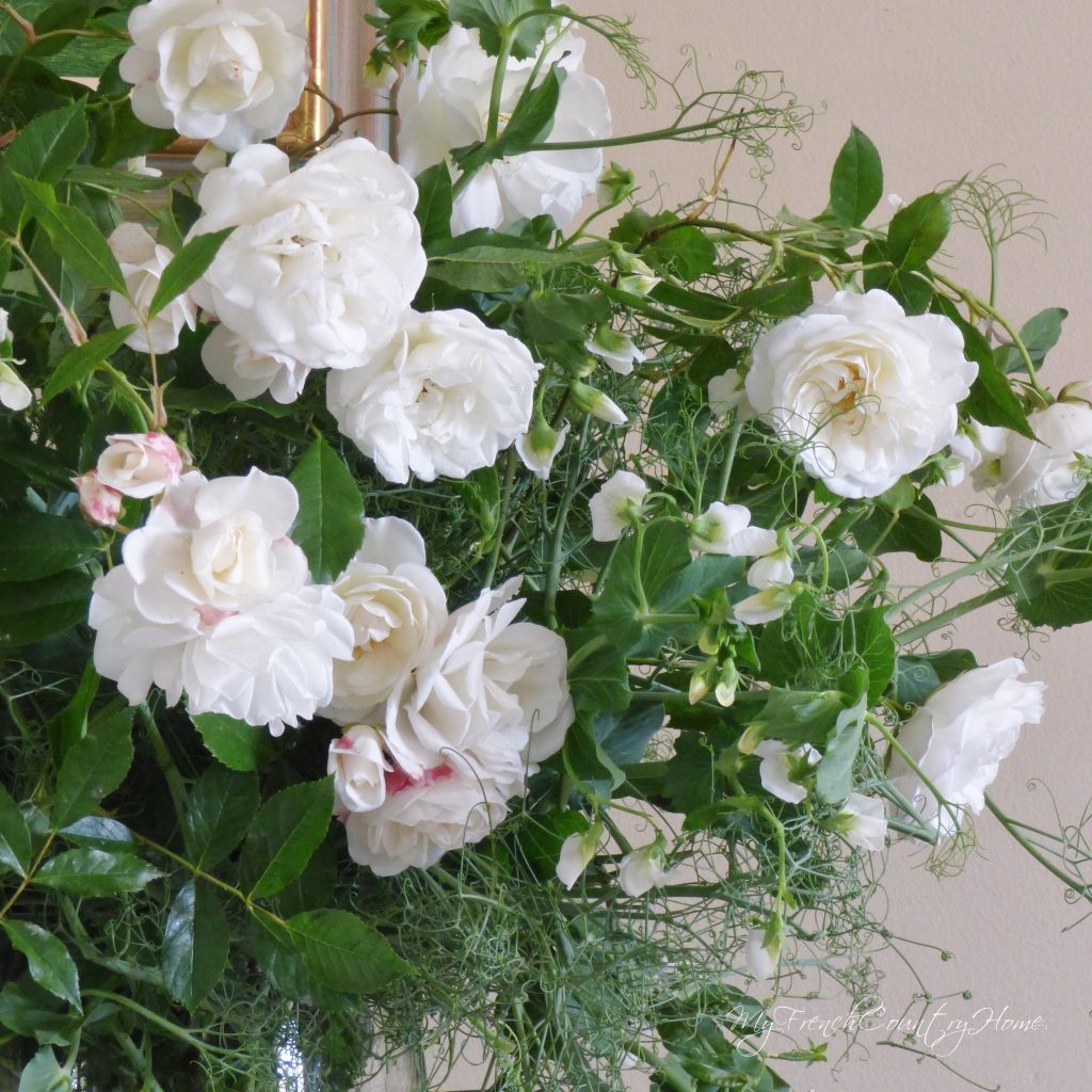 white roses and peas in a vase