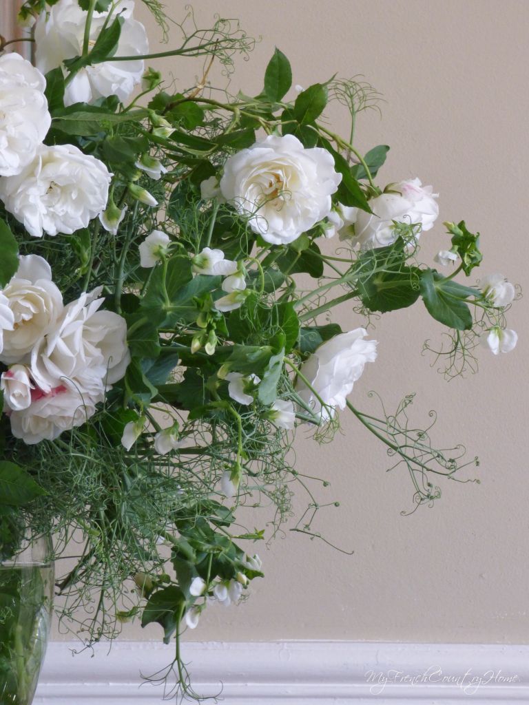 white roses and peas in a vase