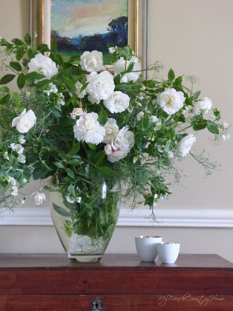 white roses and peas in a vase