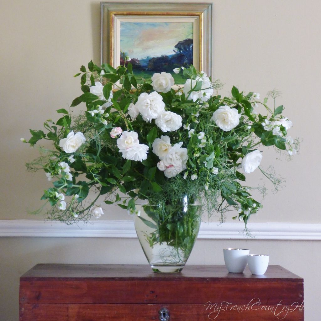 white roses and peas in a vase