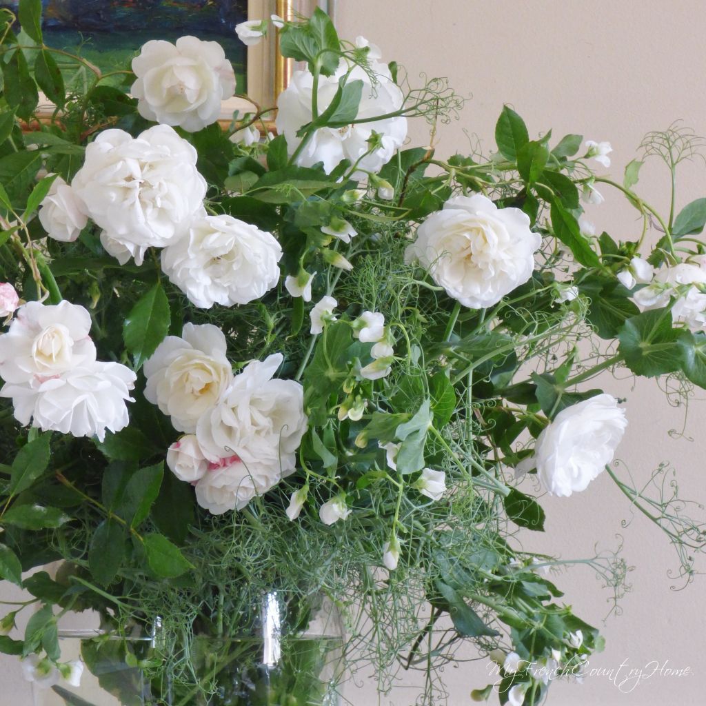 white roses and peas in a vase