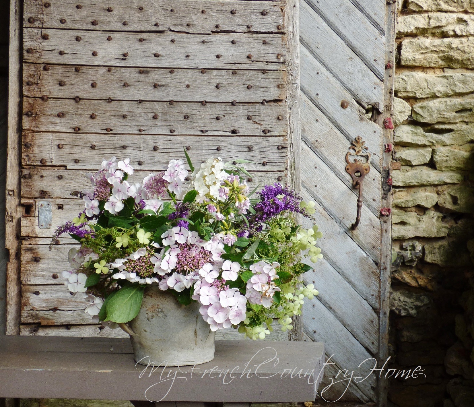 hydrangeas in a pot in front of old french doors