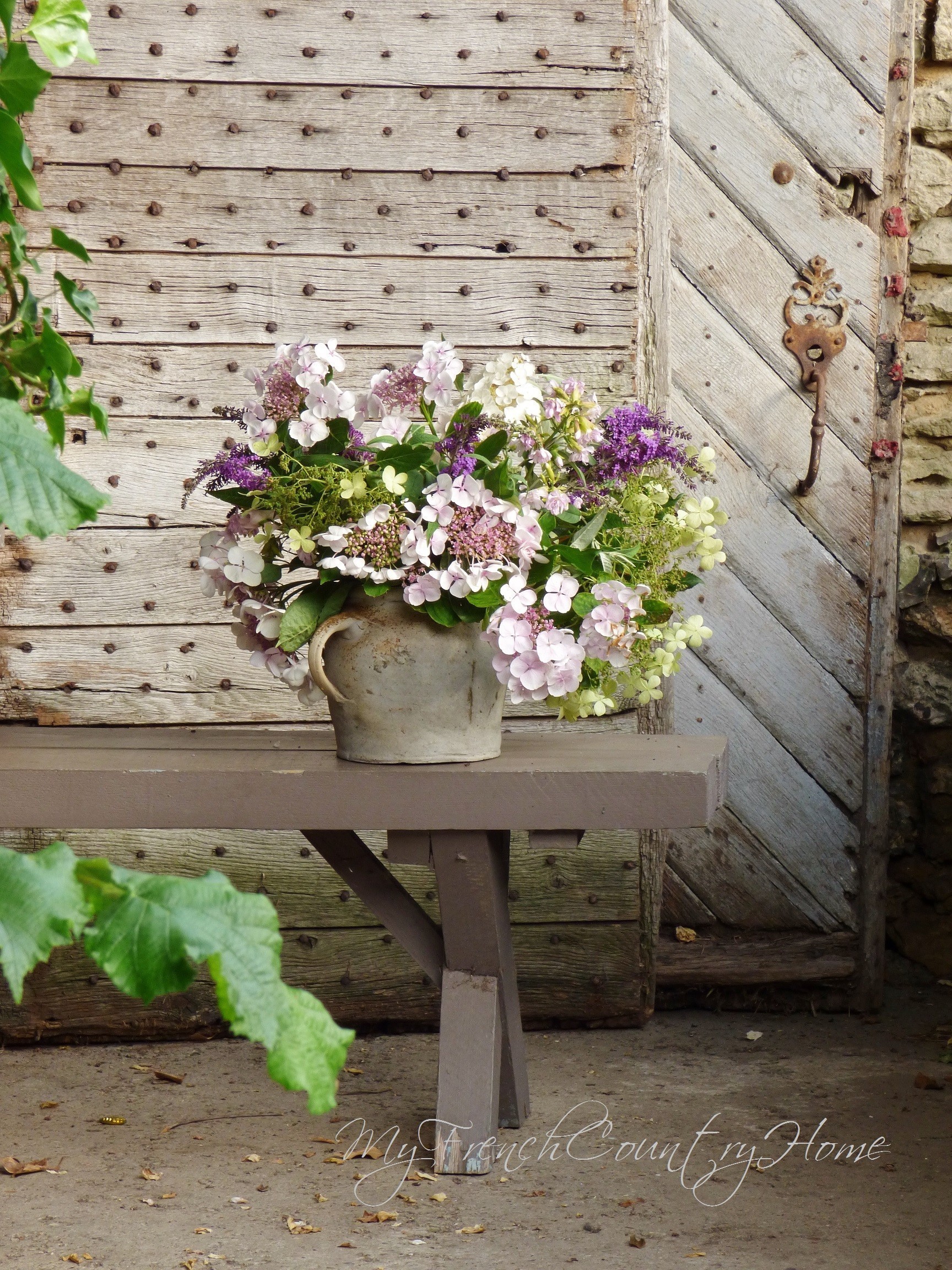 hydrangeas in a pot in front of old french doors