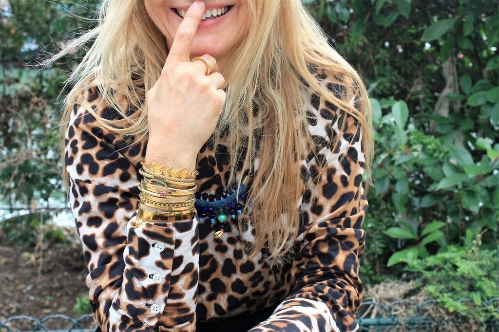 woman with jewellry on wrist and leopard print shirt