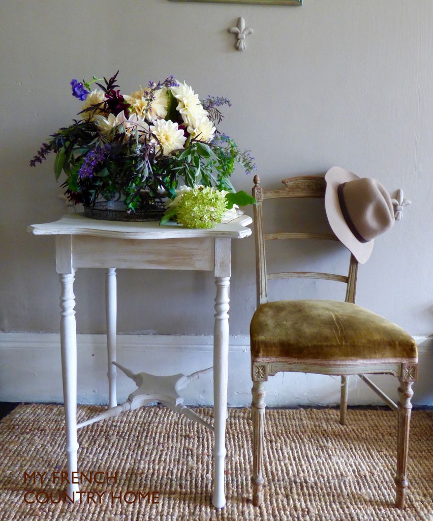 flowers on table with hat on chair