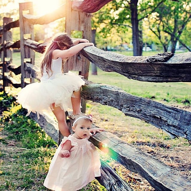 little girls playing on fence