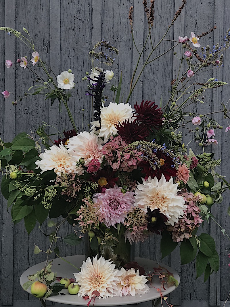 autumn flowers arranged in vase outside barn