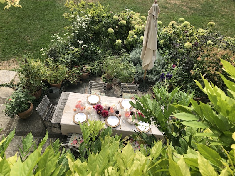 table laid on terrace with dahlias