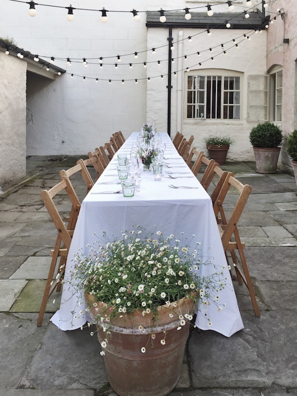 white table set outside with wood chairs