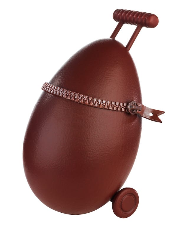 A chocolate egg transformed to look like a piece of rolling luggage