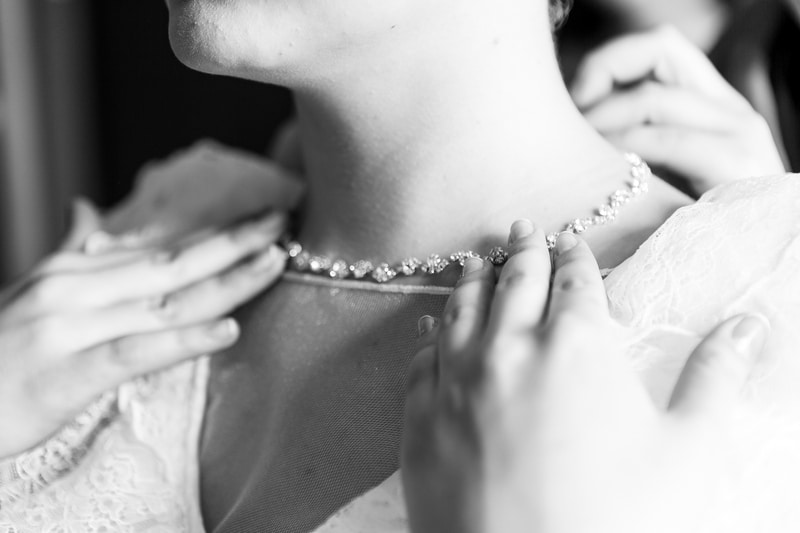 fastening necklace around bride's neck