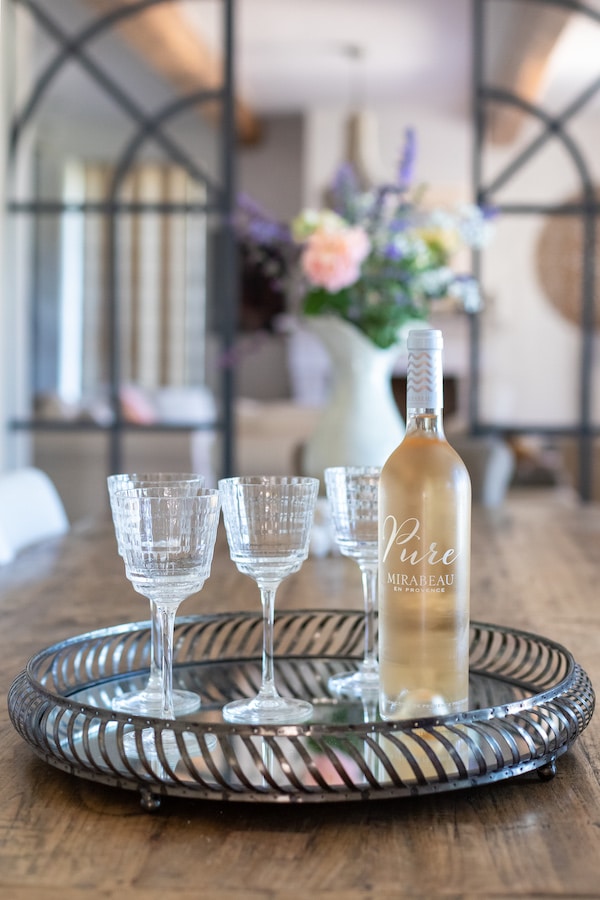 three wine glasses and bottle of rose on tray