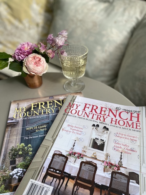 two magazines on a table with flowers and champagne