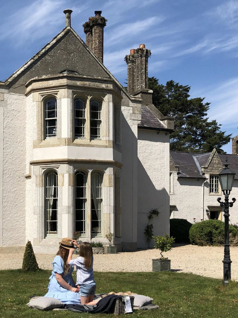 french manor home with mother and daughter on lawn